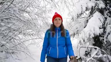 女人沿着一条小路走在美丽的冬天白雪覆盖的风景中。 <strong>晴朗晴朗</strong>的霜冻天气